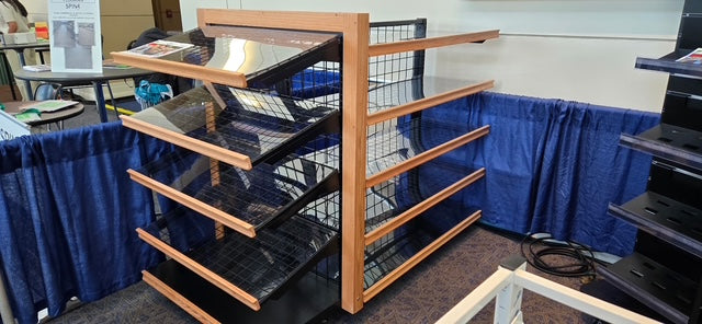 Display rack with magazines against a blue curtain in an indoor setting