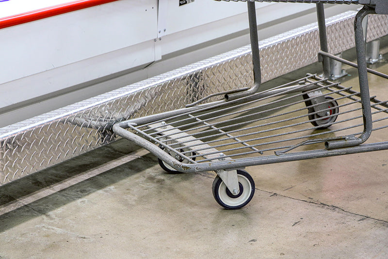 Grocery store cart slams its base into a nearby refrigerated display case
