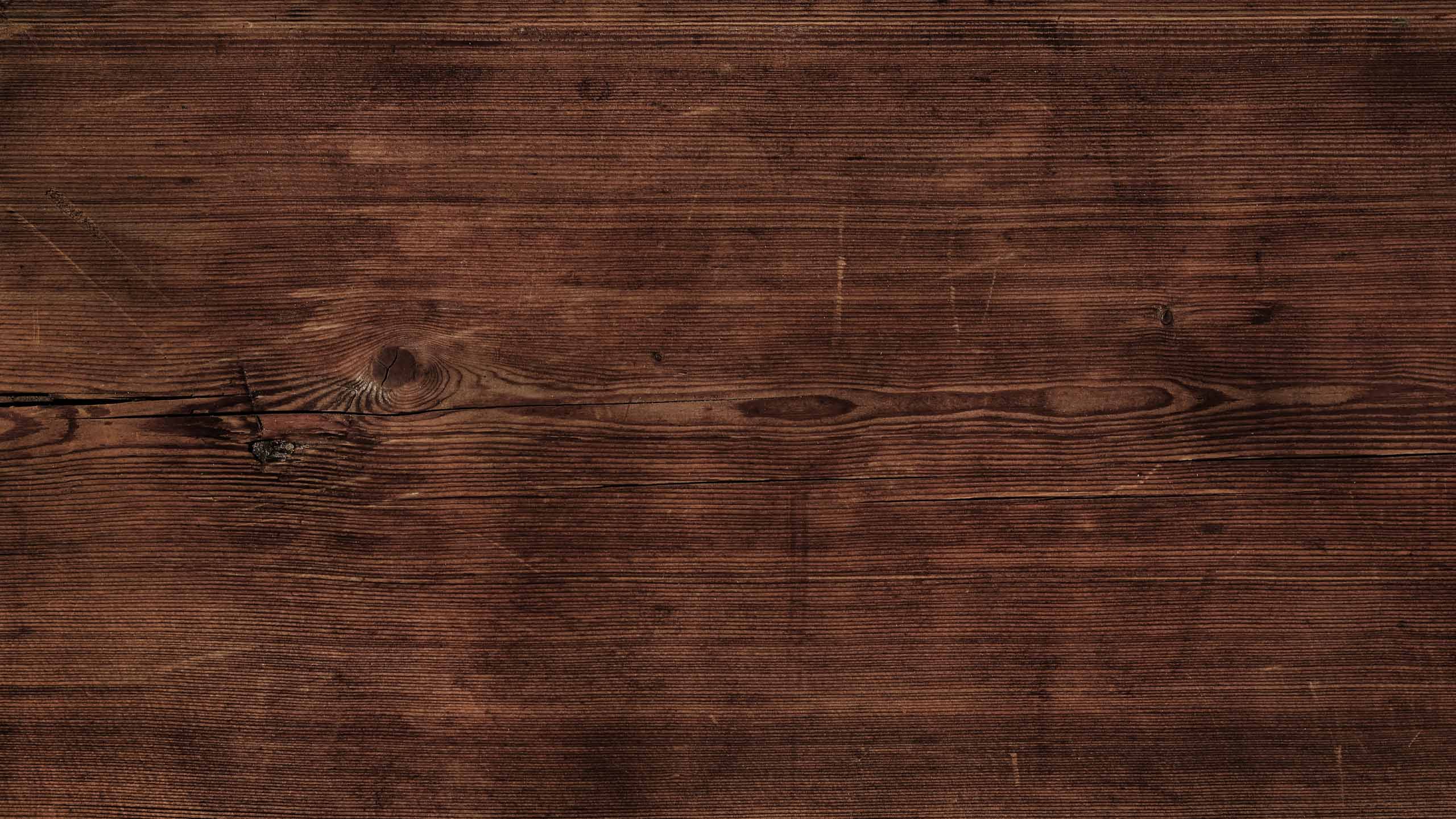 Close-up of a dark brown wooden surface with visible grain and texture