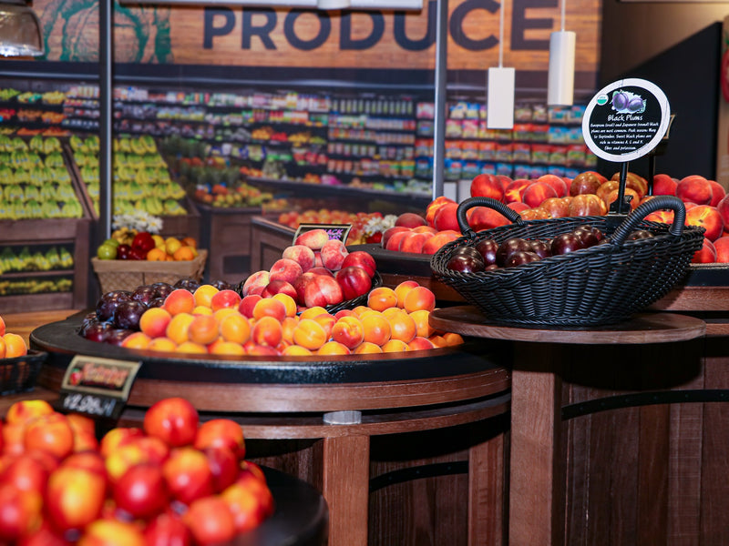 Nectarines sitting on top of a wooden grocery store display